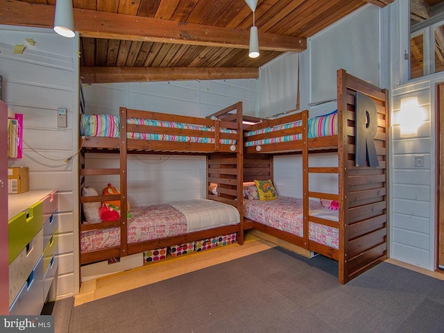 bedroom featuring vaulted ceiling with beams, wood walls, and wooden ceiling