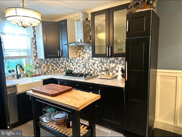 kitchen featuring light tile floors, appliances with stainless steel finishes, sink, and wall chimney range hood