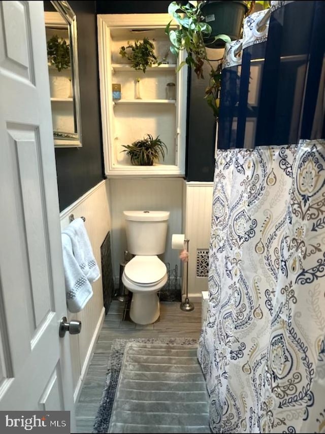 bathroom with toilet and hardwood / wood-style floors