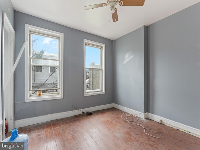 empty room with dark wood-type flooring and ceiling fan