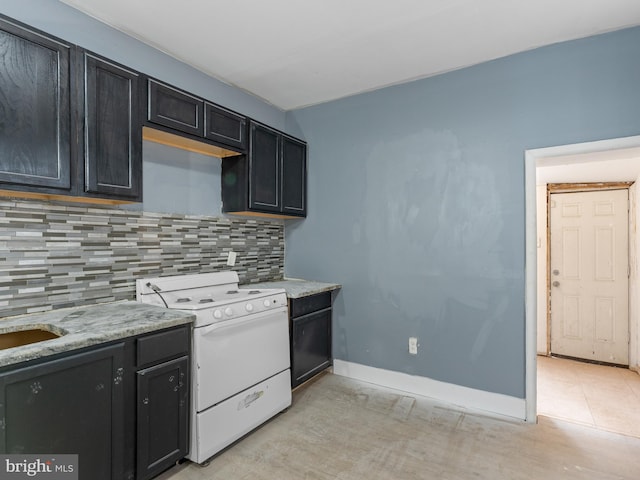 kitchen featuring white range oven, light stone countertops, tasteful backsplash, and light tile floors