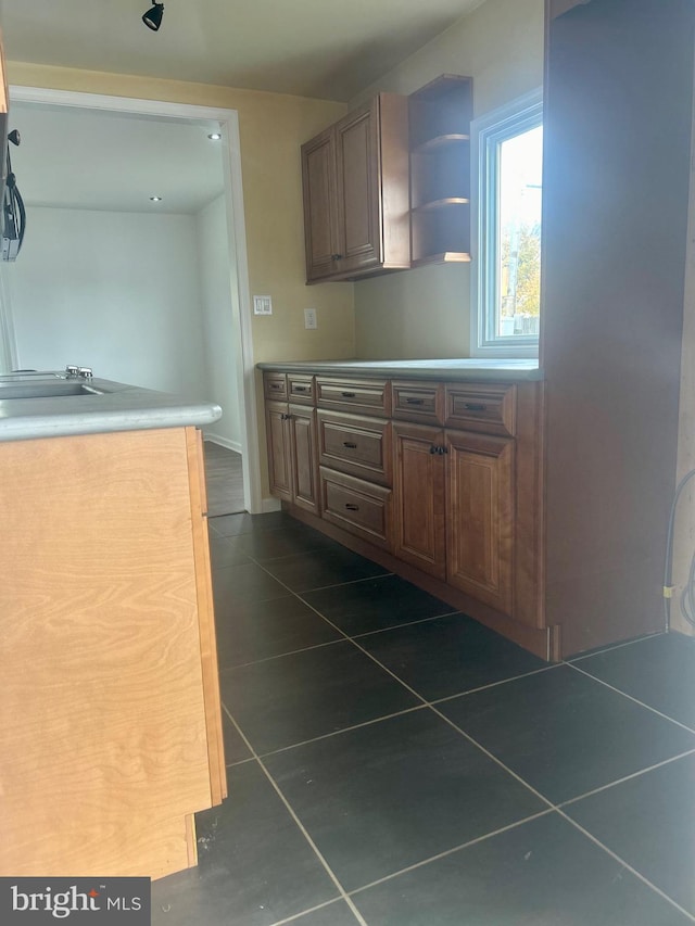 kitchen with sink and dark tile patterned flooring