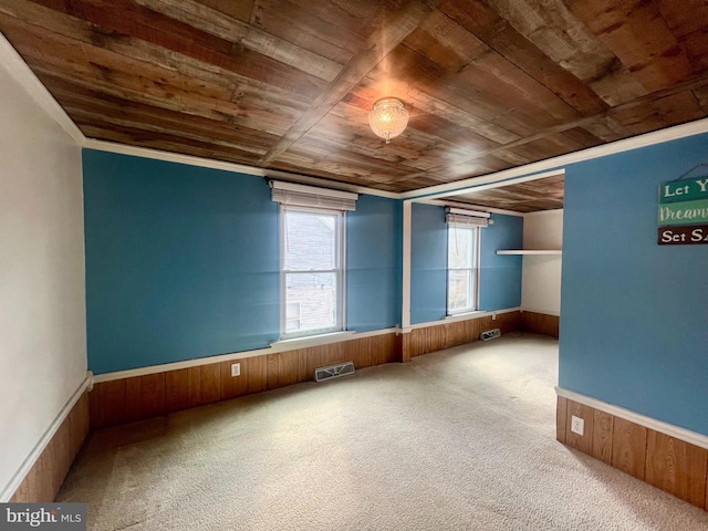 carpeted empty room with wooden ceiling and wood walls