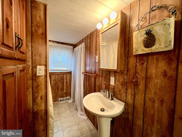 bathroom featuring tile patterned flooring, sink, wood ceiling, and wooden walls