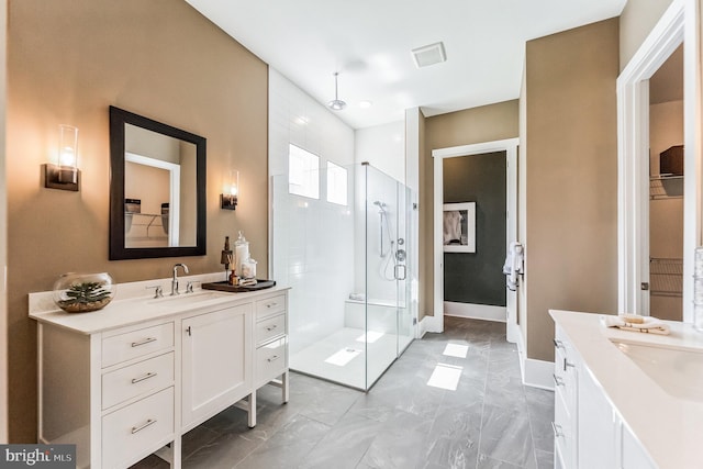 bathroom with tile floors, vanity, and a shower with door