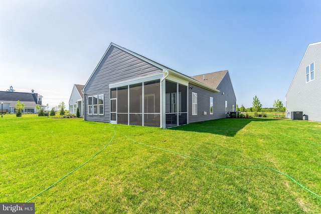 back of property with a sunroom and a lawn