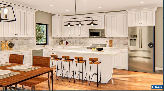 kitchen featuring a kitchen island, a kitchen bar, tasteful backsplash, light hardwood / wood-style flooring, and appliances with stainless steel finishes