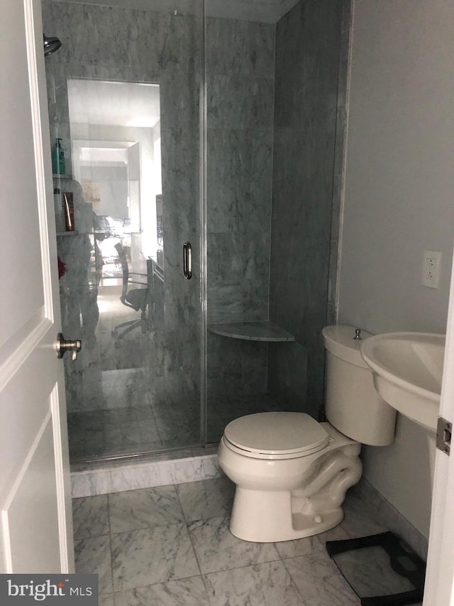 bathroom with a shower with door and toilet