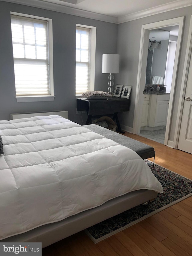 bedroom featuring light wood-type flooring and crown molding