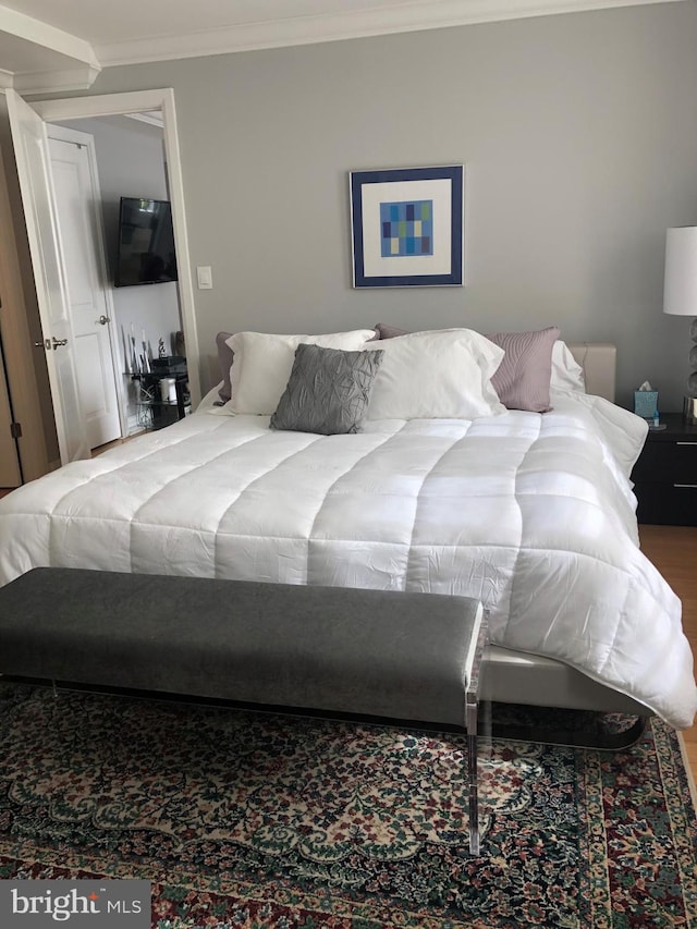 bedroom featuring hardwood / wood-style floors and crown molding