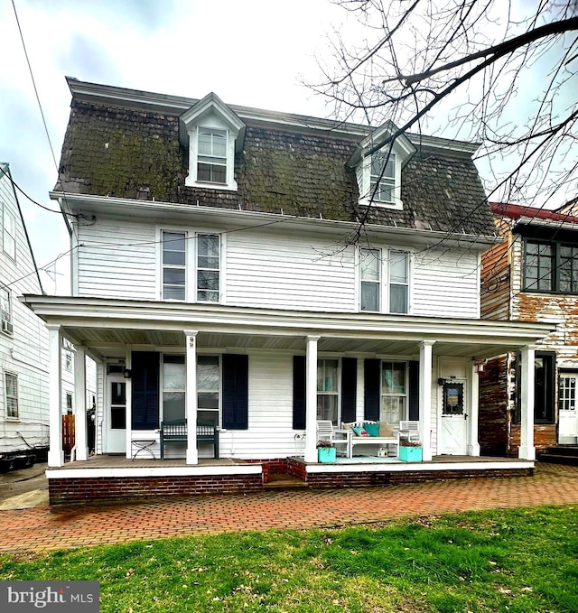 rear view of house featuring covered porch