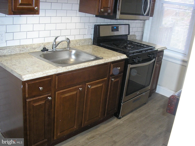 kitchen featuring light hardwood / wood-style floors, sink, tasteful backsplash, and stainless steel appliances