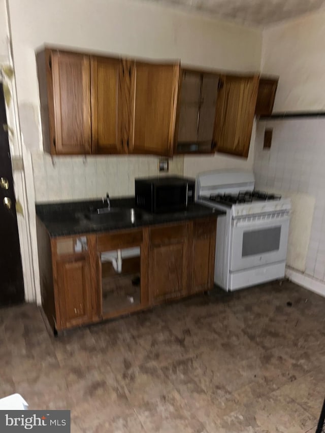 kitchen with white gas stove and sink