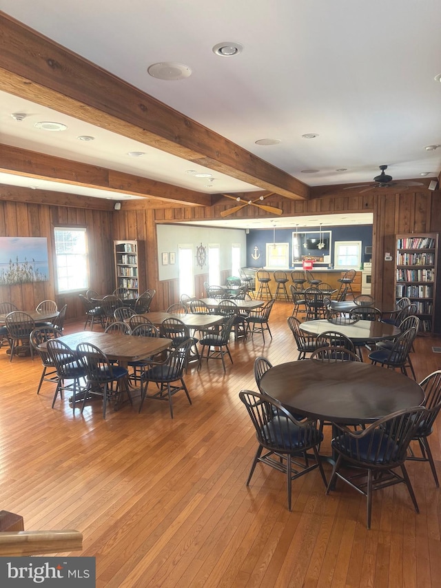 dining room with beam ceiling, ceiling fan, and light hardwood / wood-style flooring