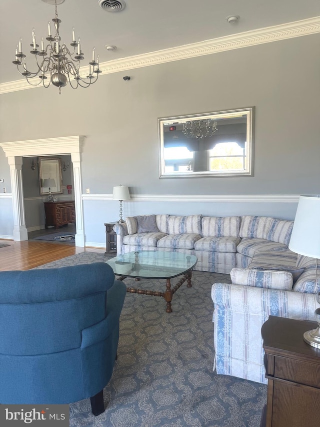 living room with an inviting chandelier, crown molding, and hardwood / wood-style floors