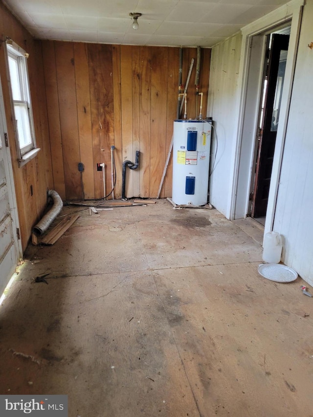 misc room featuring wood walls and water heater