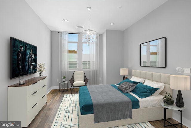 bedroom featuring a chandelier, dark hardwood / wood-style flooring, and multiple windows