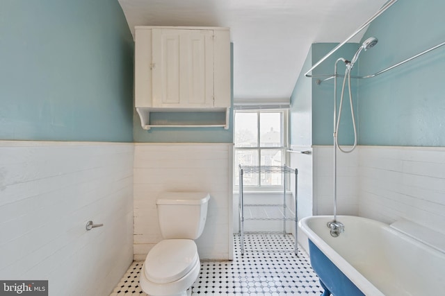 bathroom featuring toilet, tile floors, and tile walls