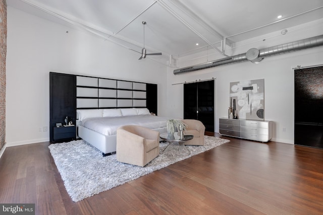 bedroom with a towering ceiling and dark hardwood / wood-style floors