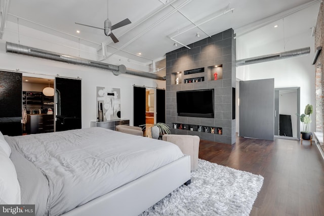 bedroom featuring dark hardwood / wood-style floors, a high ceiling, and ceiling fan