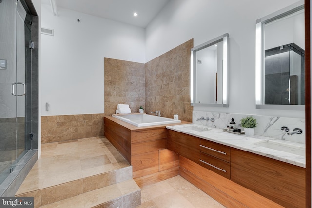 bathroom with tile walls, vanity, and separate shower and tub