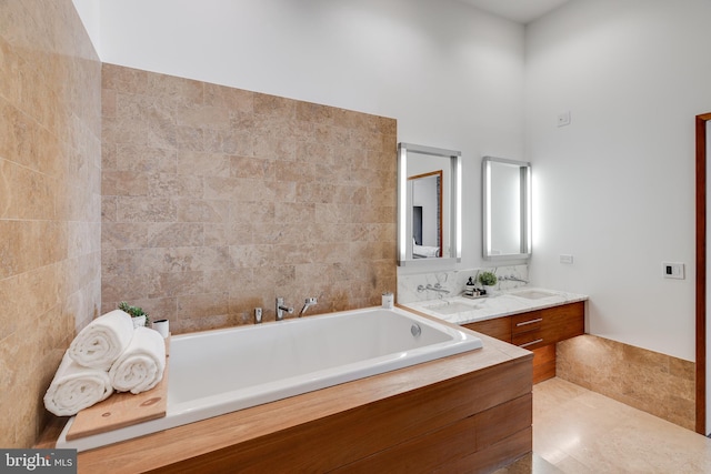 bathroom with vanity, tile walls, tile patterned floors, and a bath