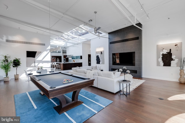 playroom with a high ceiling, pool table, and dark hardwood / wood-style flooring