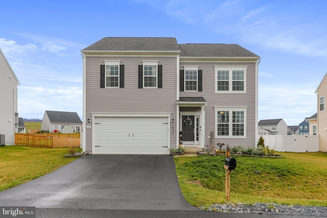 view of front facade with a front lawn, a garage, and central AC unit