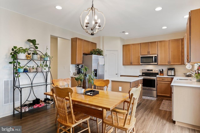 dining space featuring sink, dark hardwood / wood-style flooring, and a notable chandelier