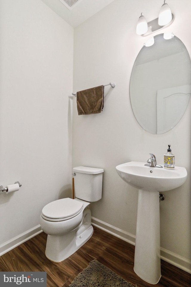 bathroom with toilet and hardwood / wood-style flooring