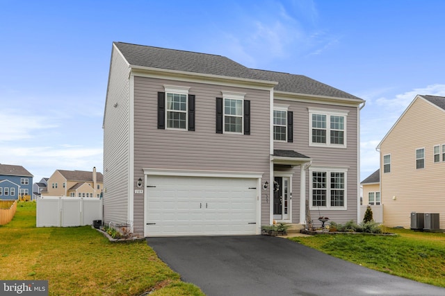 view of front of home with a front yard, a garage, and central AC unit