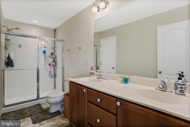 bathroom with a shower with shower door, dual bowl vanity, toilet, and tile flooring