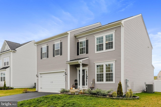 view of front of home with a front yard, a garage, and central AC