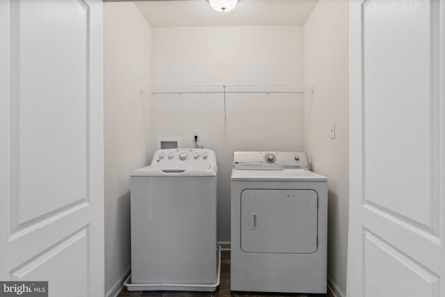 laundry area with dark wood-type flooring and washer and dryer