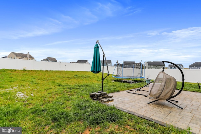 view of yard featuring a trampoline and a patio area