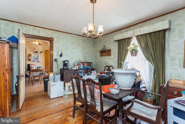 dining space with light hardwood / wood-style flooring and ceiling fan with notable chandelier