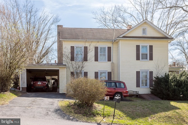 view of front facade with a front lawn and a carport