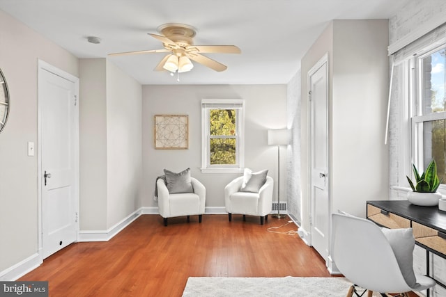 sitting room with plenty of natural light, ceiling fan, and light wood-type flooring