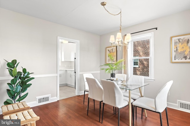 dining space with wood-type flooring and a chandelier