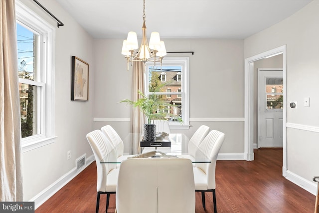 dining space with an inviting chandelier and dark hardwood / wood-style floors