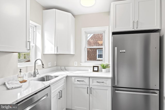 kitchen with a wealth of natural light, stainless steel appliances, and white cabinets