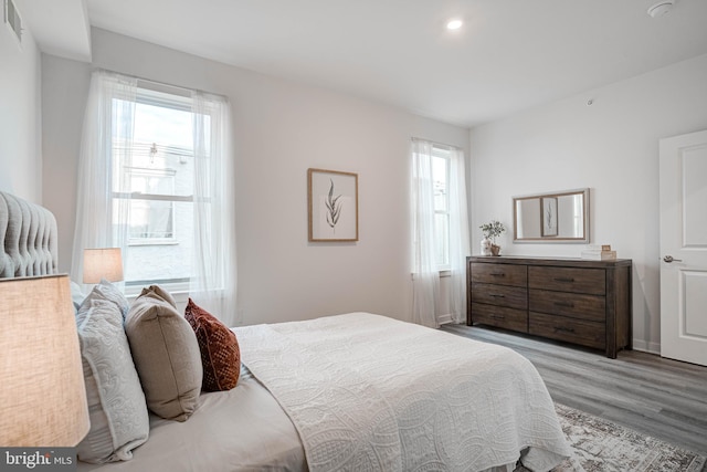 bedroom featuring multiple windows and light hardwood / wood-style flooring