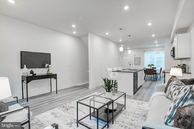 living room with light hardwood / wood-style floors and sink