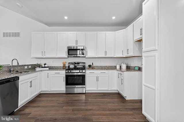 kitchen featuring stainless steel appliances, dark hardwood / wood-style flooring, sink, white cabinetry, and light stone counters