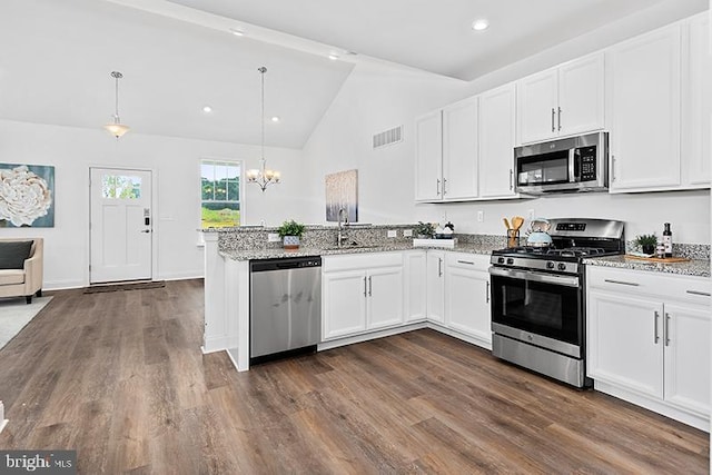 kitchen featuring dark hardwood / wood-style floors, pendant lighting, light stone counters, white cabinets, and stainless steel appliances