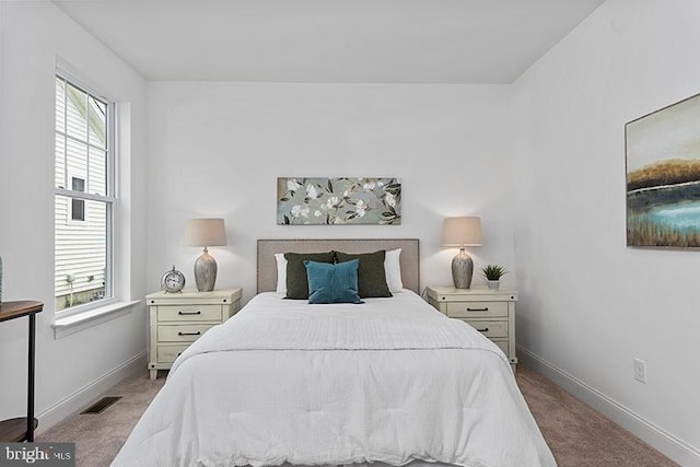 bedroom with light carpet and multiple windows