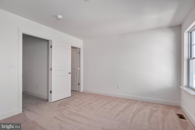 carpeted spare room featuring plenty of natural light