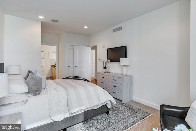 carpeted bedroom featuring ensuite bath