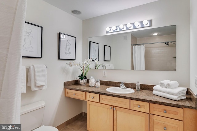 bathroom with tile flooring, toilet, and vanity