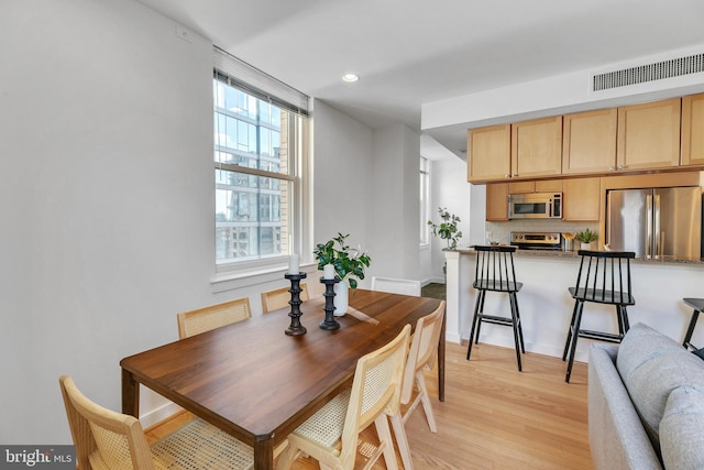 dining space with light wood-type flooring and a wealth of natural light